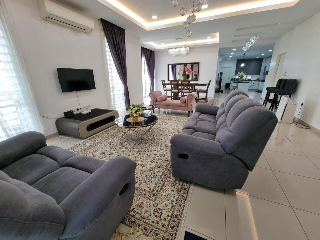 LabuAluha Homestay Sendayan with Swimming Pool的客厅配有两张沙发和一台电视机