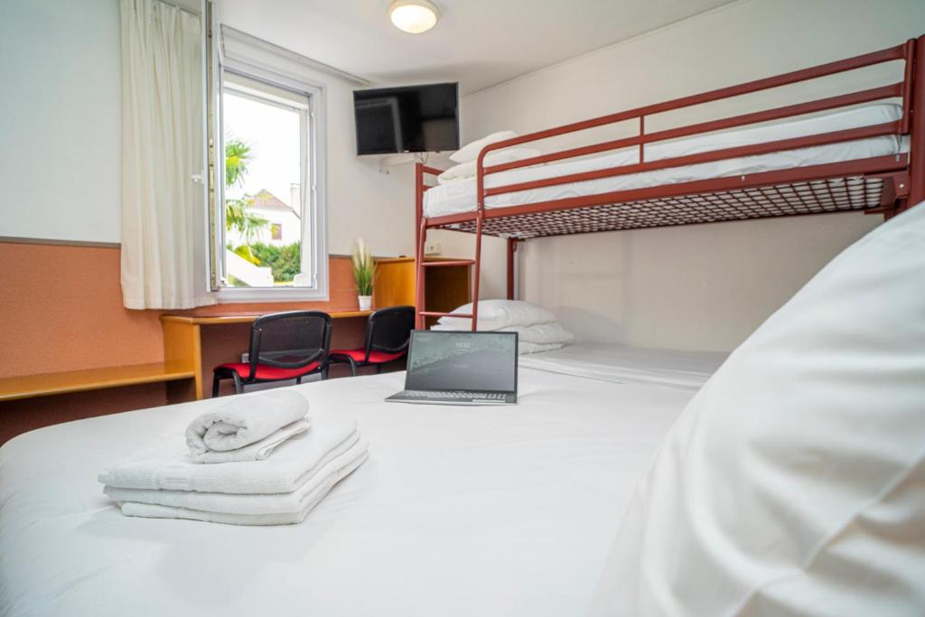 波城Quick Palace Pau Zénith的一间卧室配有一张带笔记本电脑的床