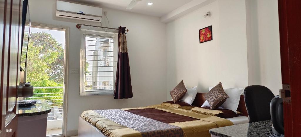 迈索尔Sugamya Corner Guesthouse的一间卧室设有一张床和一个大窗户