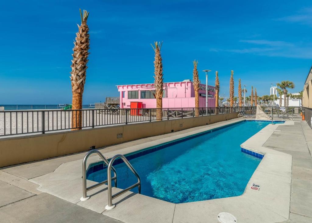格尔夫海岸Phoenix All Suites by Brett Robinson的棕榈树和海滩的游泳池