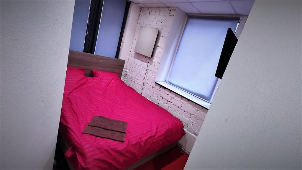 基辅Міні Готель "БУНКЕР" на Солом'янському的一间小卧室,房间内设有一张红色的床