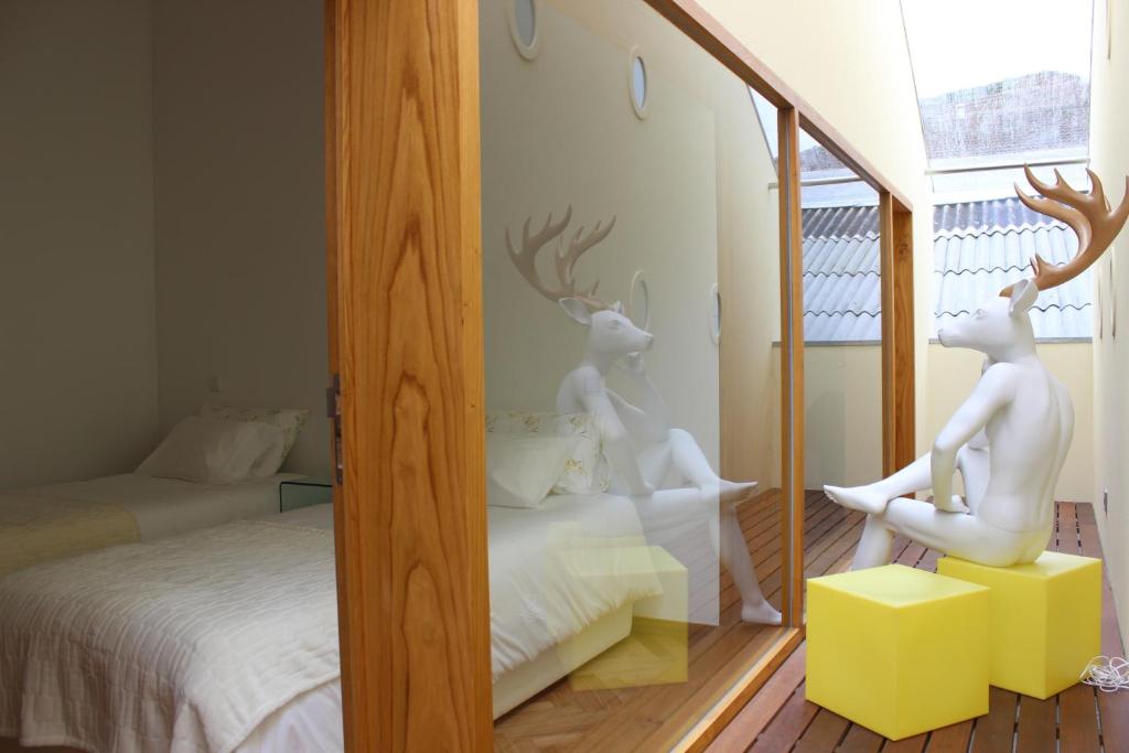 加亚新城Groove-Wood Loft的卧室内一面镜子和两座白鹿雕像