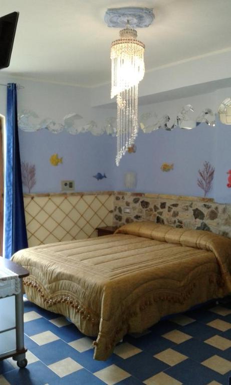 希拉Olimpo Palace Affittacamere的一间卧室配有一张大床和一个吊灯。