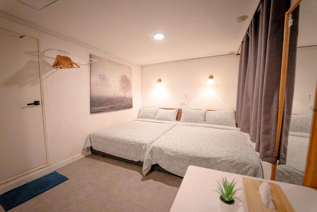 首尔首尔大厦旅馆的一间小卧室,配有一张床和一张桌子