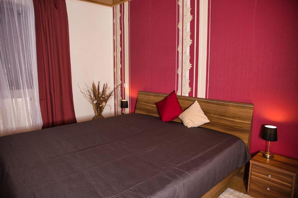 Haus Waldblick的一间卧室配有黑色床和红色墙壁