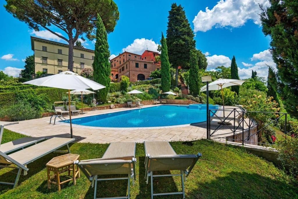 圣米尼亚托Borgo Bucciano的庭院内的游泳池,配有椅子和遮阳伞