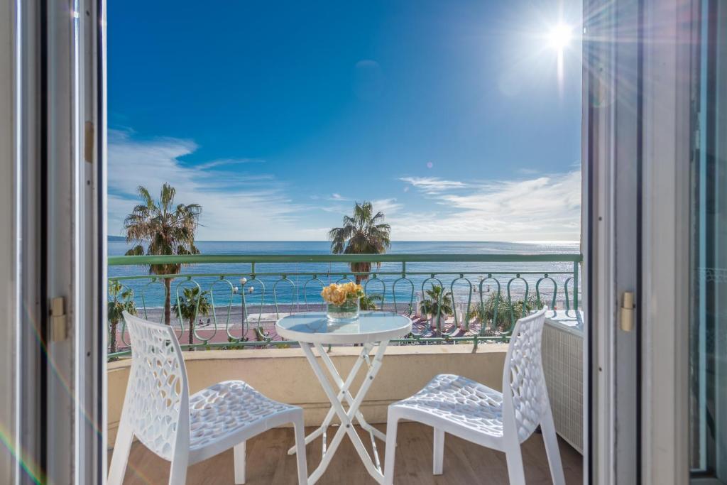 尼斯SEA FRONT - Panoramic view with Terraсe - 2BR的阳台配有桌椅,享有海景。