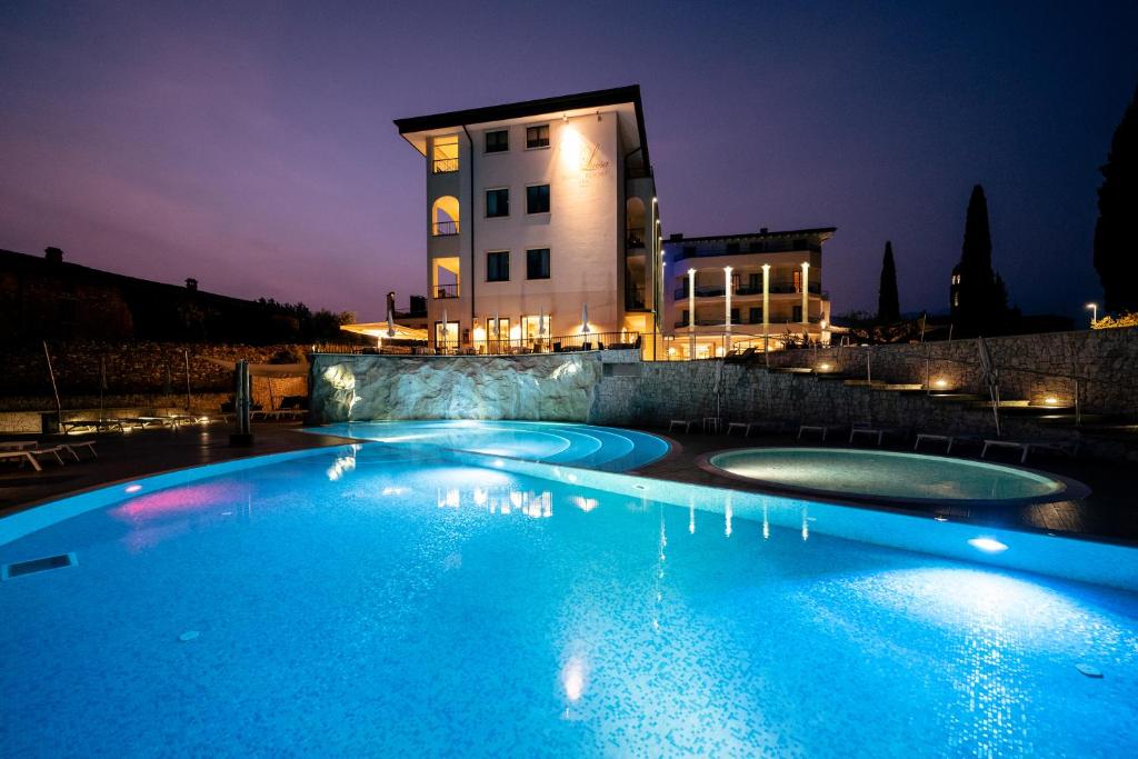 圣费利切德尔贝纳科路易莎别墅度假酒店的一座游泳池,在晚上在建筑物前