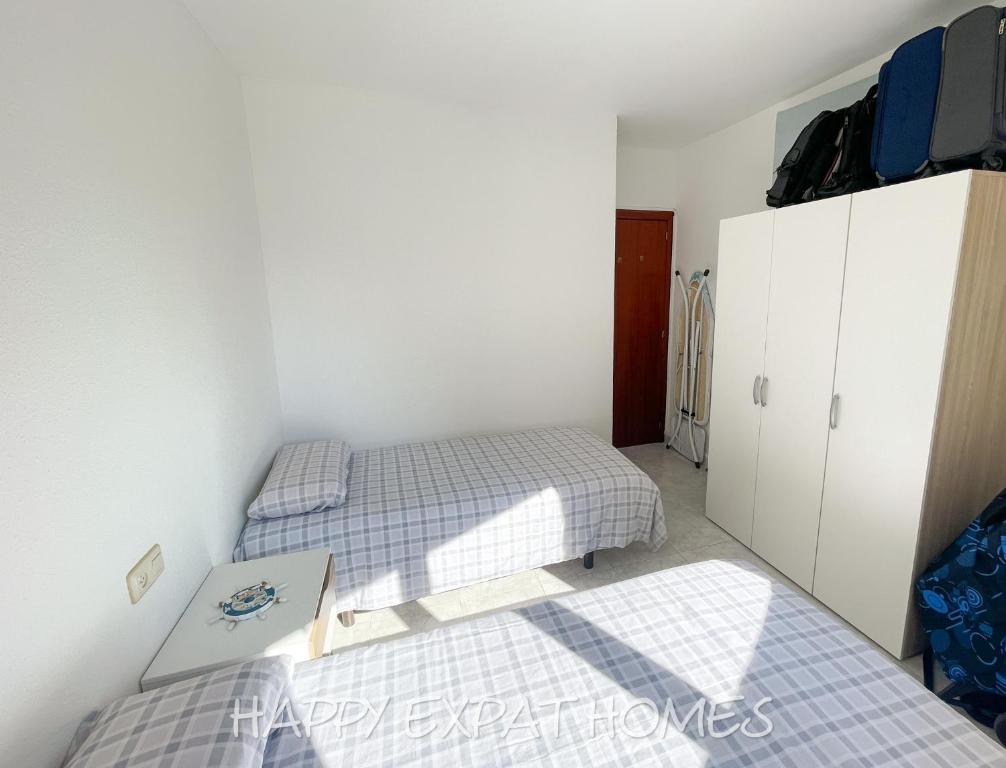 塞古德卡拉斐Playa y confort en Segur de Calafell的一间设有两张床的房间和一个橱柜