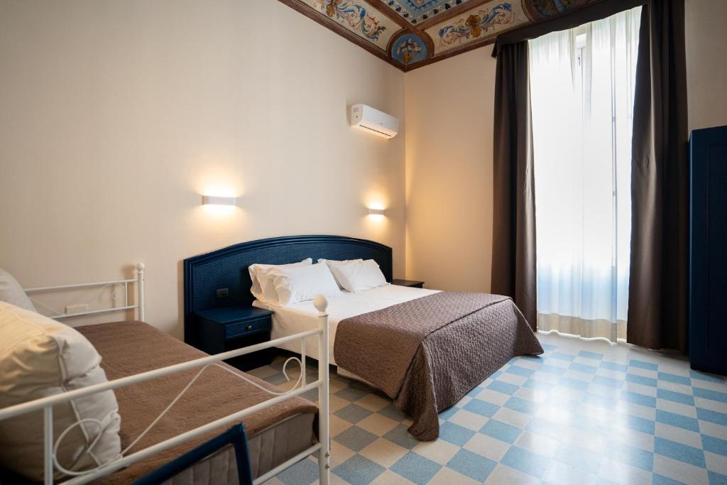 锡拉库扎Gran Bretagna Boutique Hotel Ortigia的酒店客房设有两张床和窗户。