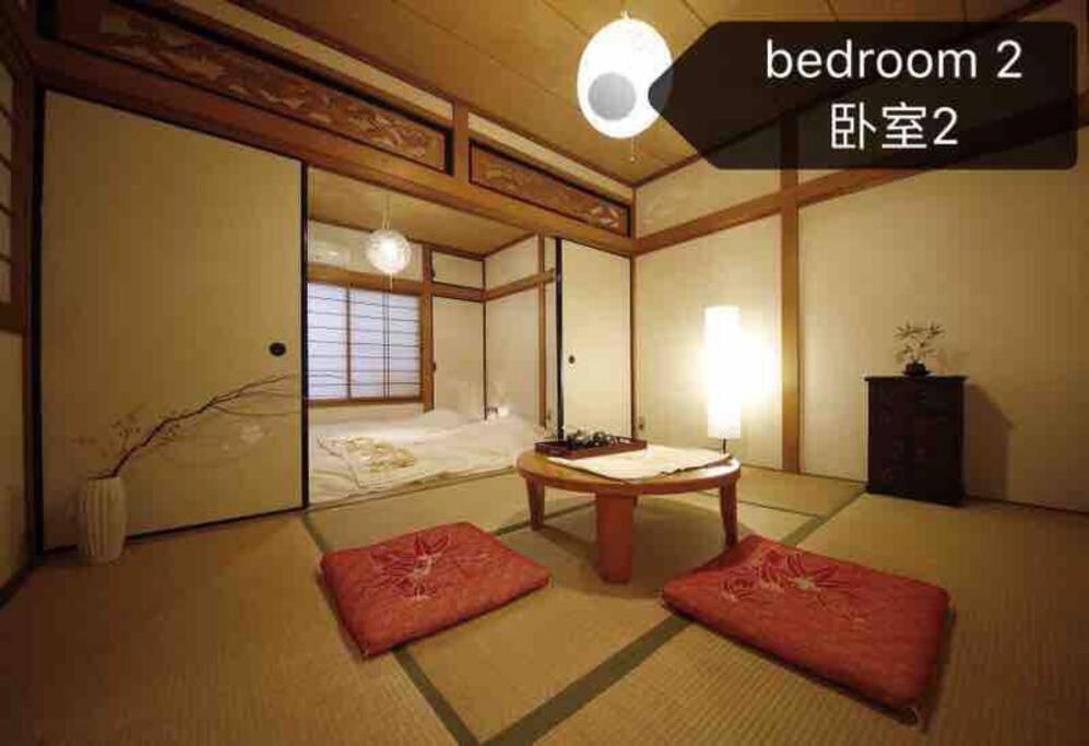 大阪Osaka KAYA Traditional Tatami house 2-6 ppl near station and park direct to KIX airport的一间房间,配有一张桌子和两个红色垫子