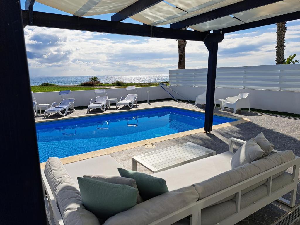 马佐托斯Villa Waves的带沙发和游泳池的天井