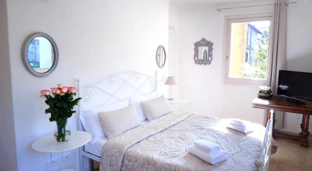 贝加莫Academia Resort的一间白色的卧室,配有一张床和花瓶
