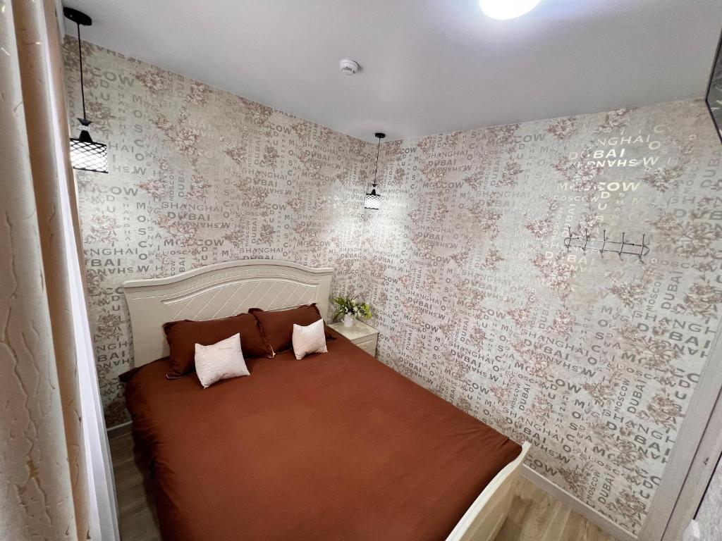 乌斯季卡缅诺戈尔斯克Sport Hotel Terra的一间卧室配有床和壁纸覆盖的墙壁