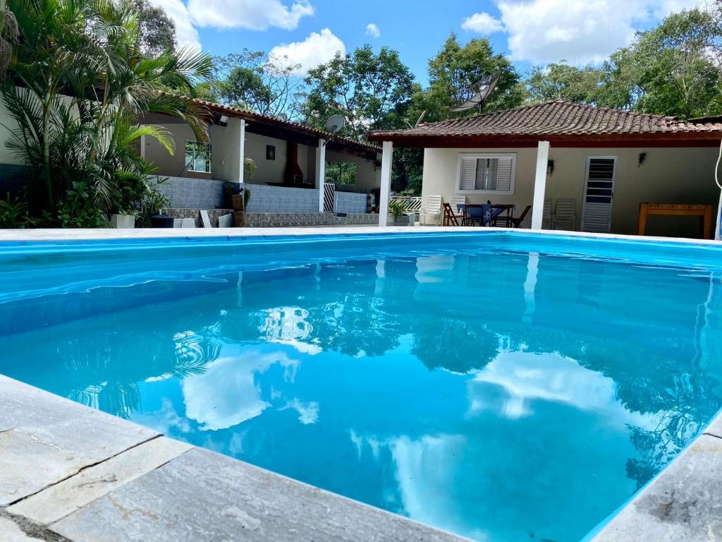 迈里波朗Chácara das Suculentas的一座房子前面的蓝色海水游泳池