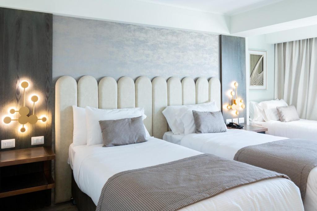 圣地亚哥Hotel HW High Wellness的酒店客房,配有两张带白色床单的床