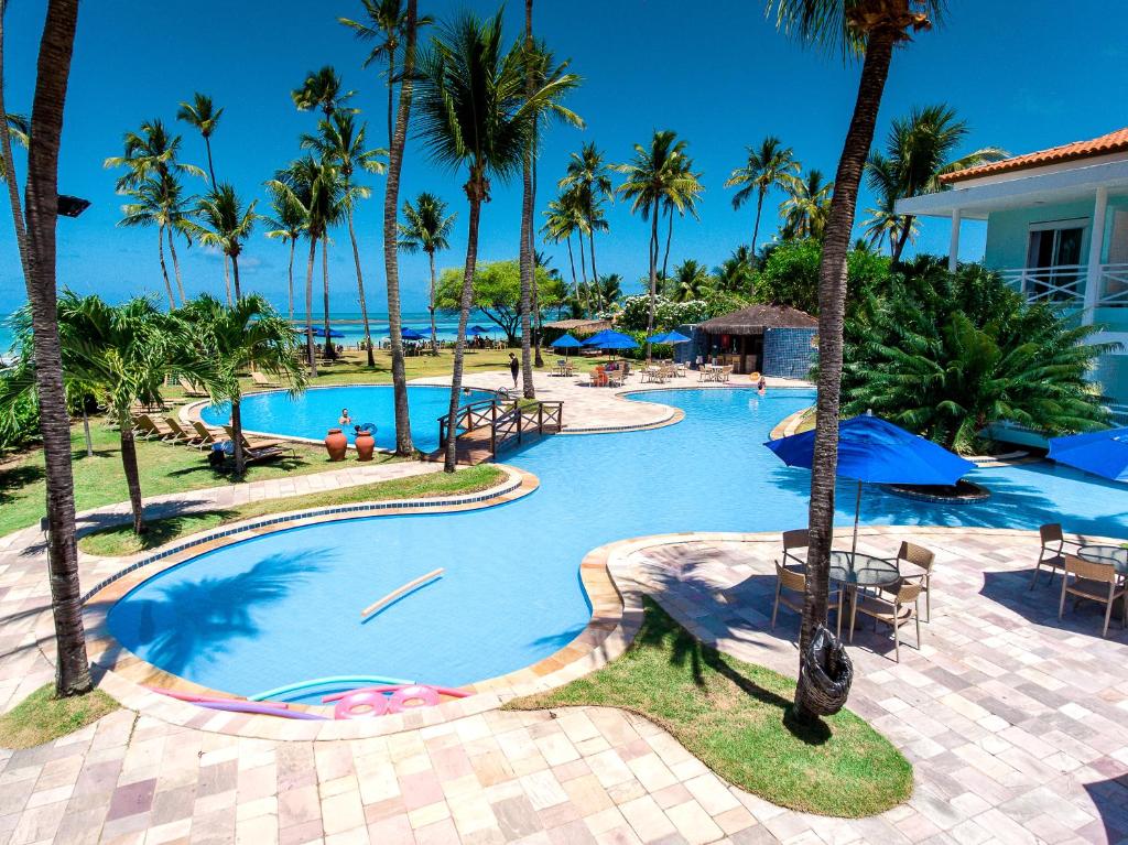 塔曼达雷Baía Branca Beach Resort的棕榈树游泳池及度假村