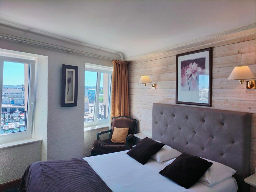 瑟堡Logis HOTEL RESTAURANT La Régence的一间卧室配有一张床、一把椅子和窗户。