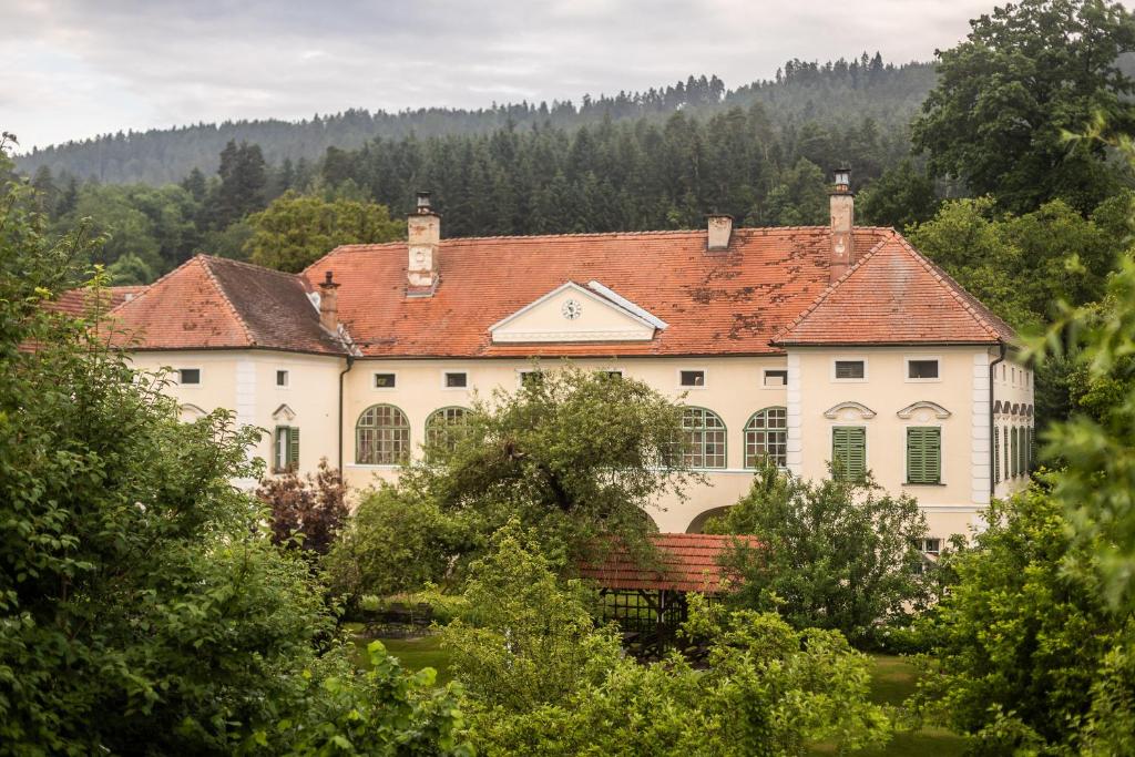 克拉根福Schlossgut Gundersdorf的一座大型白色房屋,设有红色屋顶