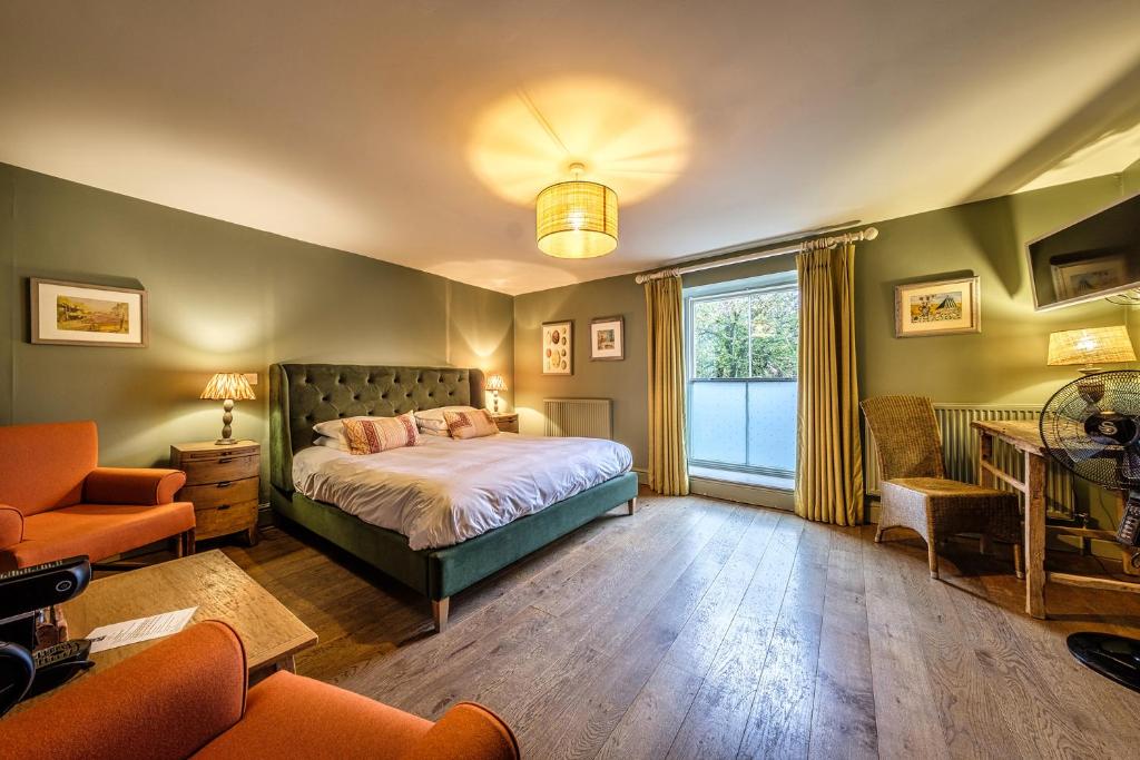 海滨韦尔斯港The Globe Inn的卧室配有床、椅子和窗户。