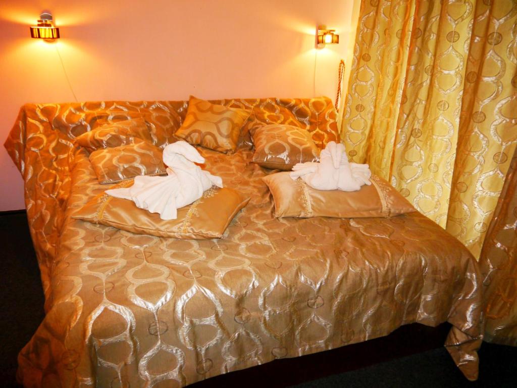 哈尔科夫Kizhi ART Hotel Kharkiv的两个天鹅坐在床上,床上有枕头