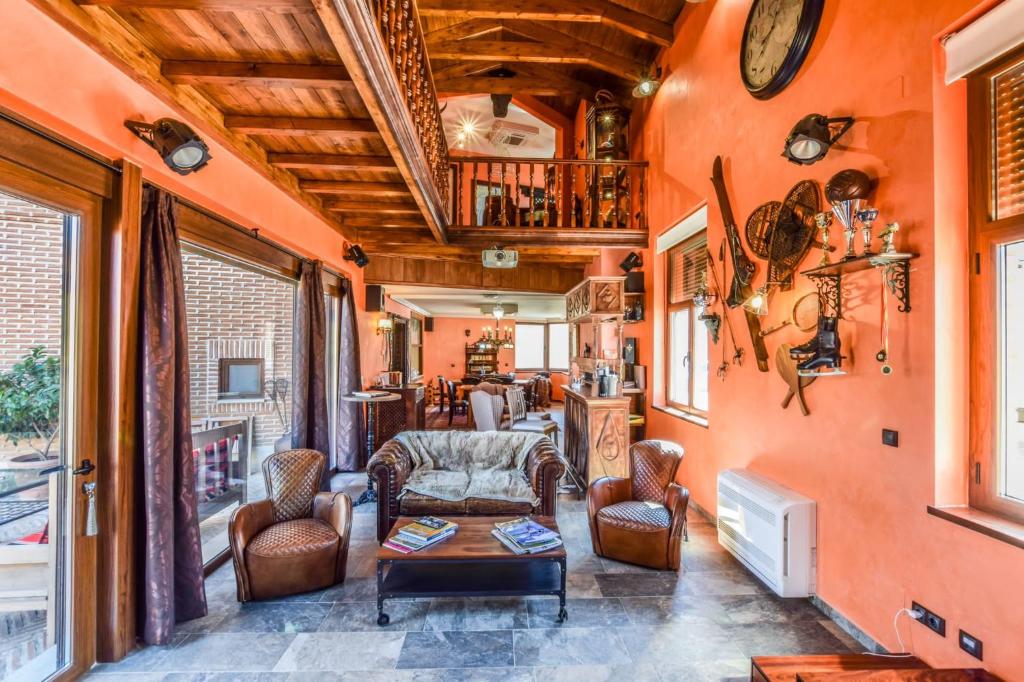 Villamayor de CamposCasa del Trotamundos的客厅设有橙色墙壁和桌椅