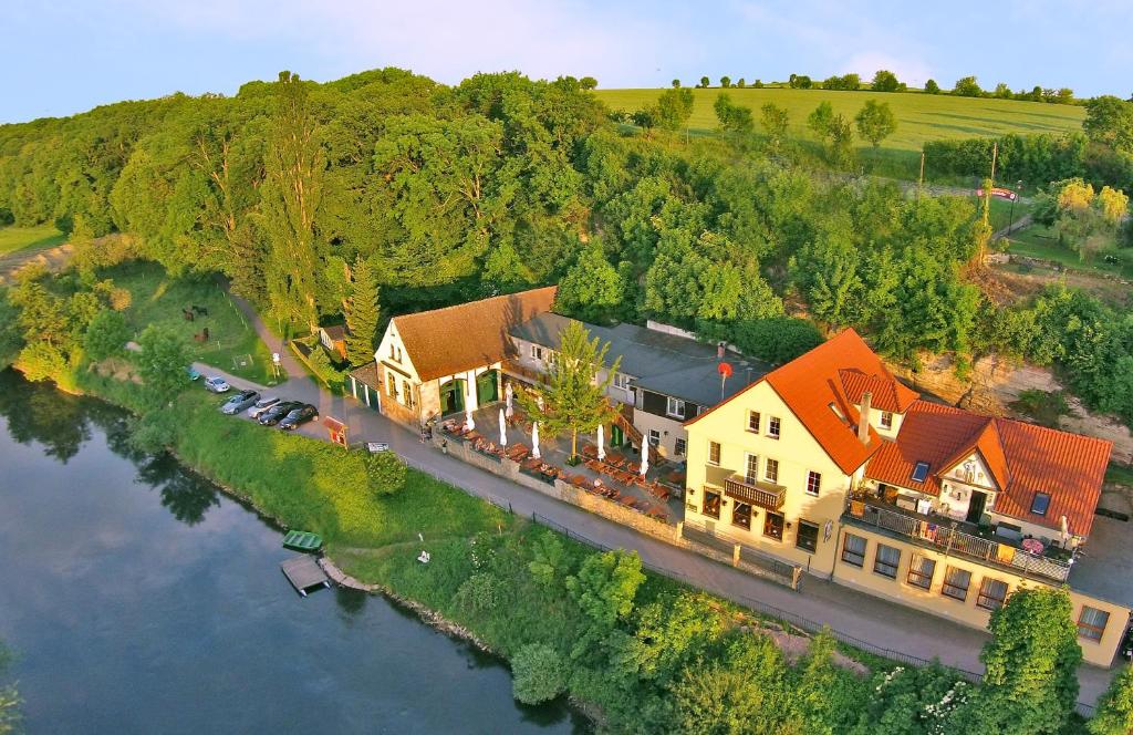 萨勒河畔瑙姆堡阿尔特费尔斯柯勒宾馆的享有河流上一座大房子的空中景致