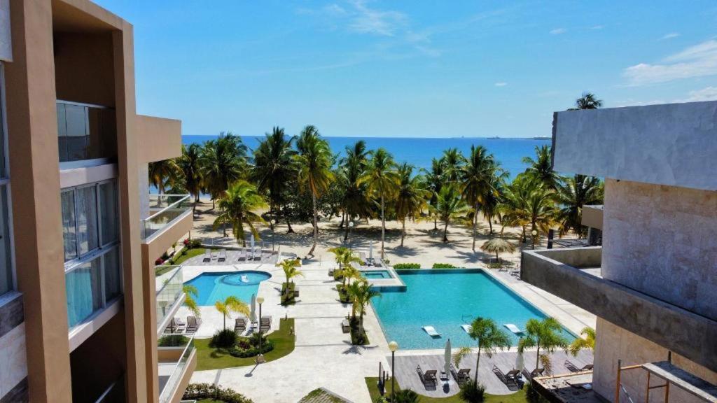 圣佩德罗-德马科里斯Exclusivo apartamento frente al mar的享有度假村的空中景致,设有游泳池和棕榈树