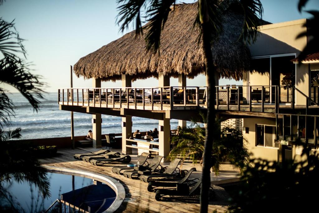 拉利伯塔德德玛别墅酒店的一个带躺椅的度假胜地,一个码头和大海