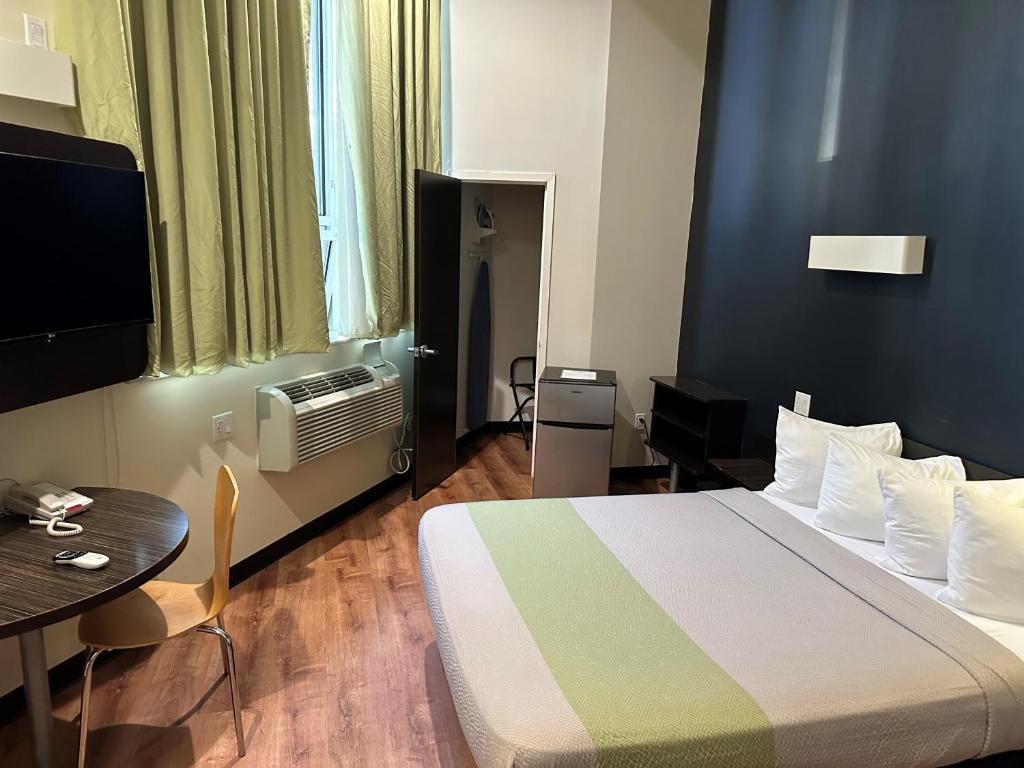 皇后区羽毛厂酒店 的酒店客房配有一张床铺和一张桌子。