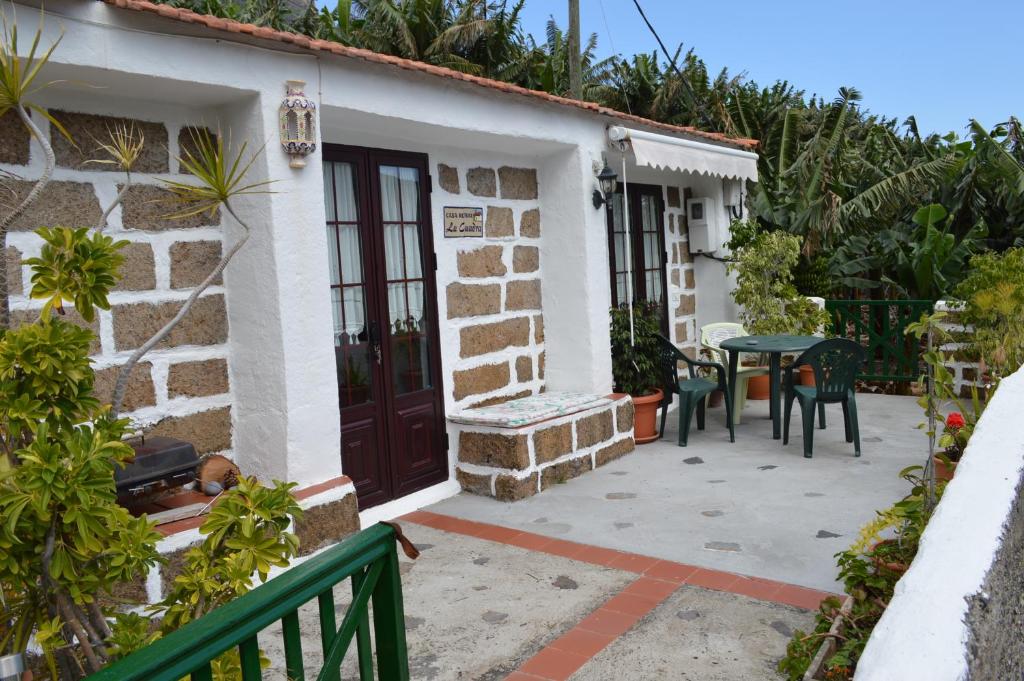 埃尔米瓜拉夸德拉度假屋的房屋设有带桌椅的庭院
