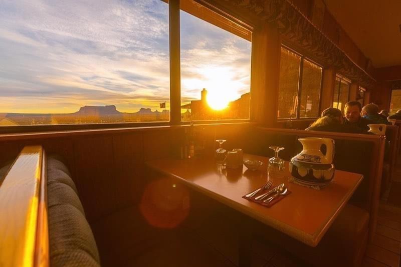 莫纽门特谷地古尔丁小屋酒店的餐厅内一张桌子,背靠日落