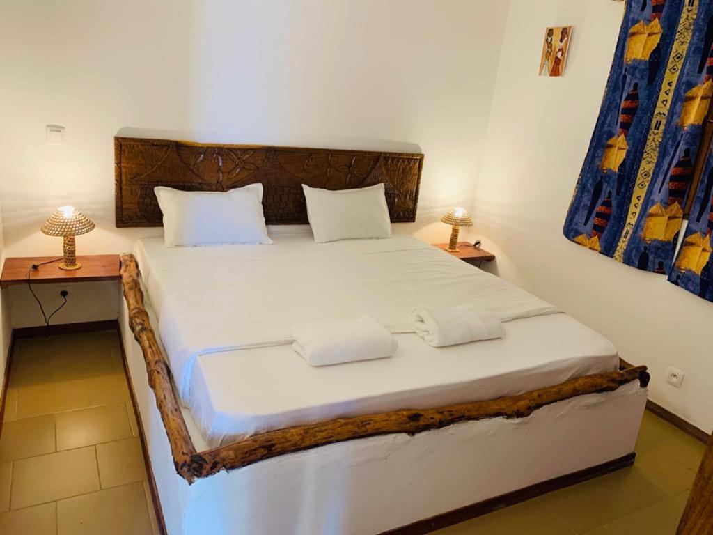 斯基灵角Villa Nemocotier的卧室配有一张带两张桌子的大型白色床