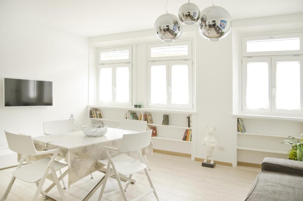 博尔扎诺格林公寓的白色的客厅配有白色的桌子和椅子