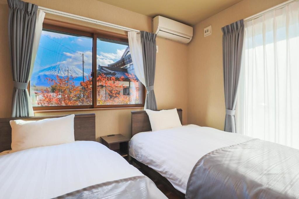 鸣泽市24 ORIYA Mt Fuji -鳴沢 NARUSAWA-的带窗户的客房内的两张床