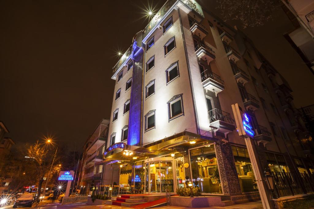 安卡拉安卡拉皇家酒店的一座高大的白色建筑,上面有蓝色的灯光