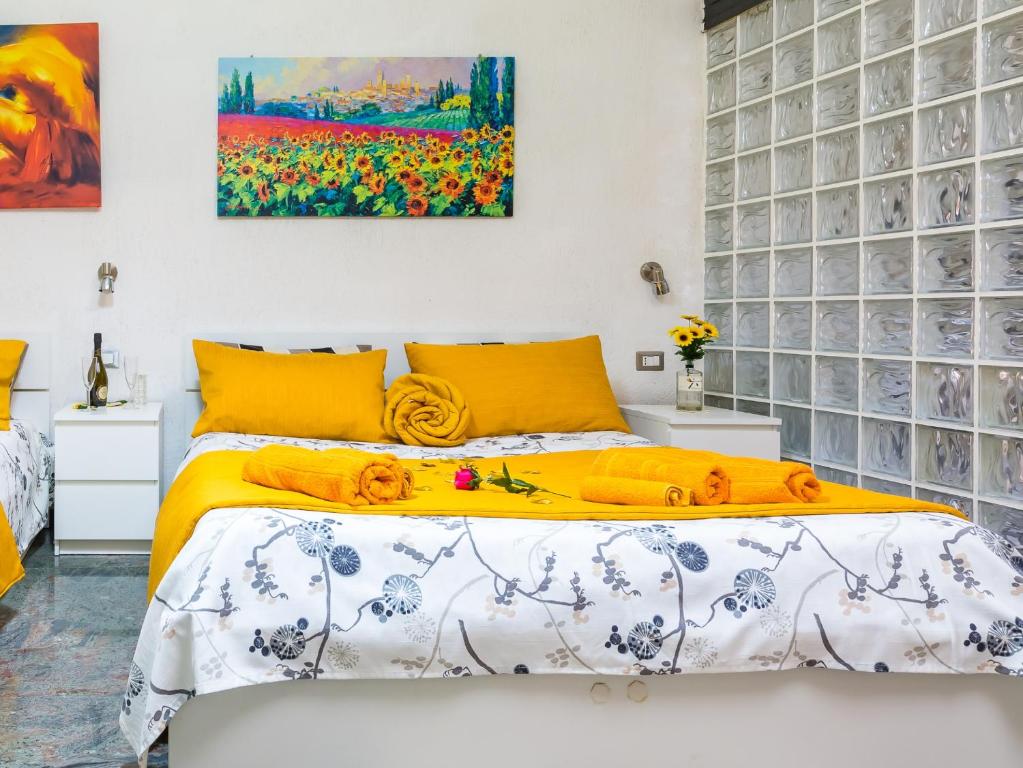 那不勒斯Museo Filangieri Apartment-Suite的一间卧室配有一张黄色床单和墙上的绘画。