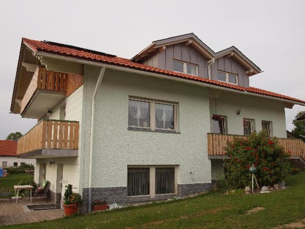 毛特Ferienwohnung Christa的白色的房子,设有木制阳台和庭院