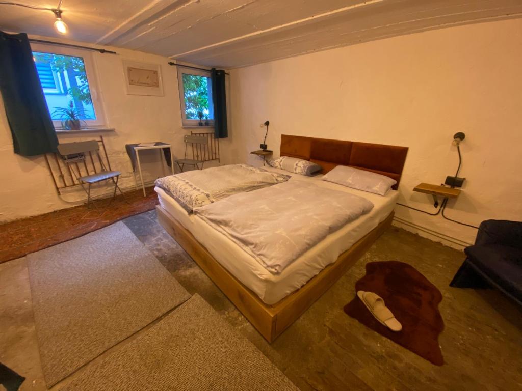 门登Art Boutique Budget Apartment im Hinterhof Menden Altstadt的一间卧室配有一张床,客厅配有椅子
