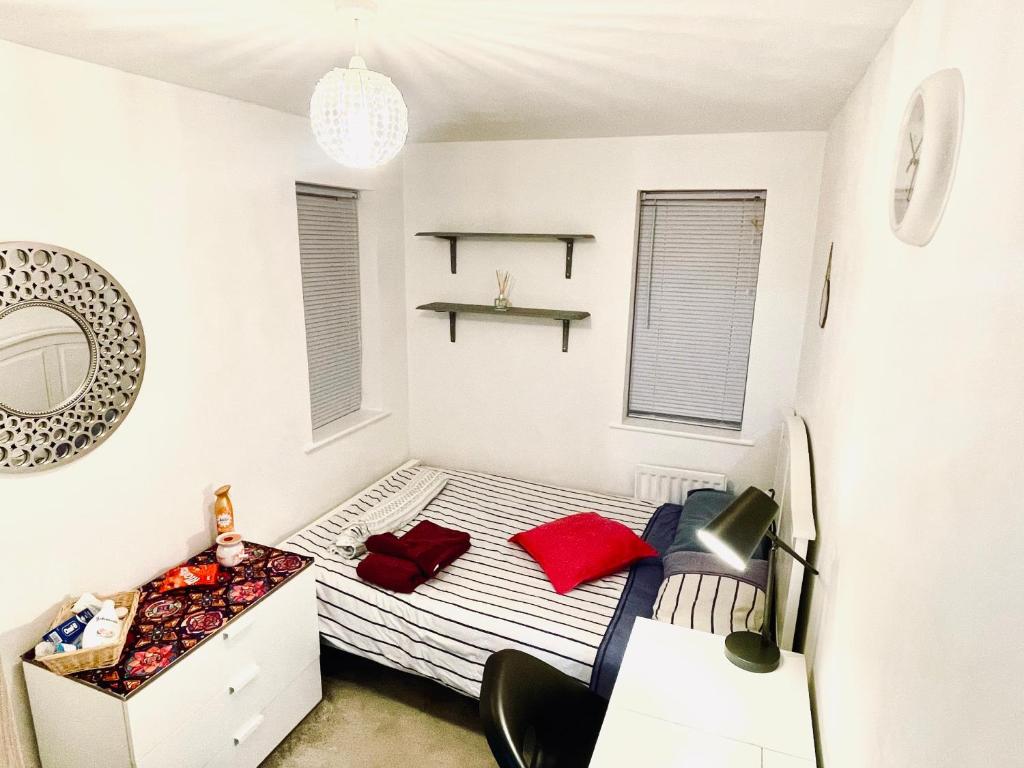 布里斯托Private room in BS14的小卧室配有红色枕头的床