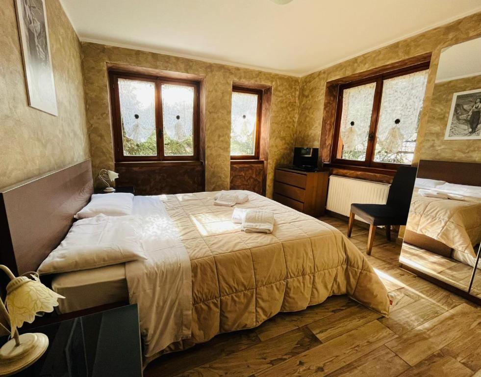坎波多尔奇诺San Luigi - Rooms & Apartments的一间卧室设有一张大床和两个窗户。