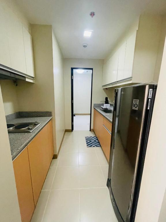伊洛伊洛1 Bedroom Condo unit @ Iloilo Business Center的厨房配有不锈钢冰箱