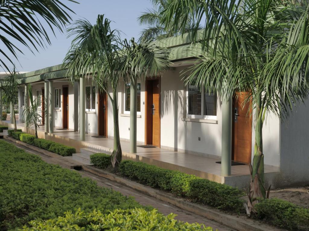 朱巴Grand Hotel Juba的前面有棕榈树的房子