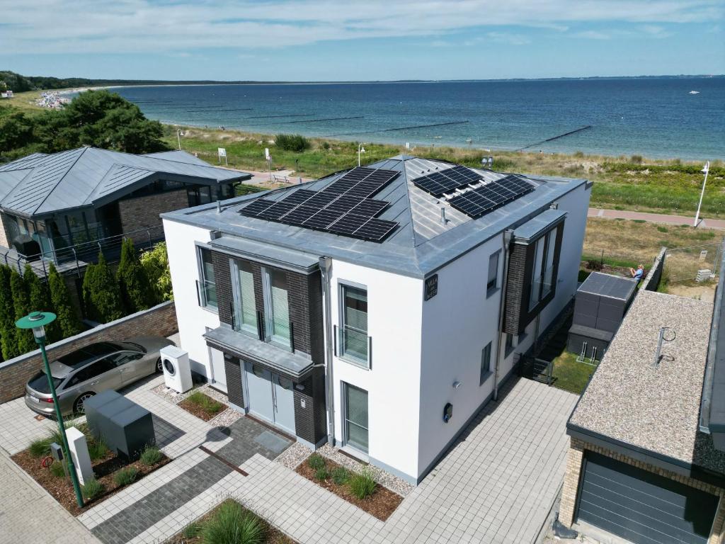 格洛韦Villa Am Meer Glowe Apartment EG的屋顶上设有太阳能电池板的房子
