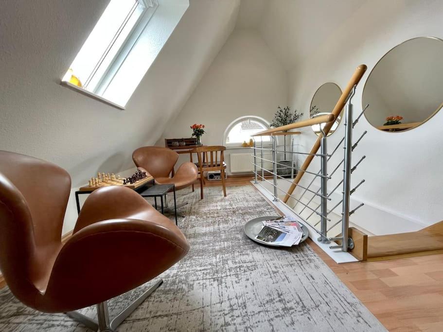 吕贝克Modernes, familienfreundliches Apartment in Lübeck的一间带楼梯、椅子和镜子的客厅