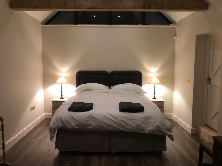 科尔切斯特The Stables的一间卧室配有一张大床,上面有两盏灯