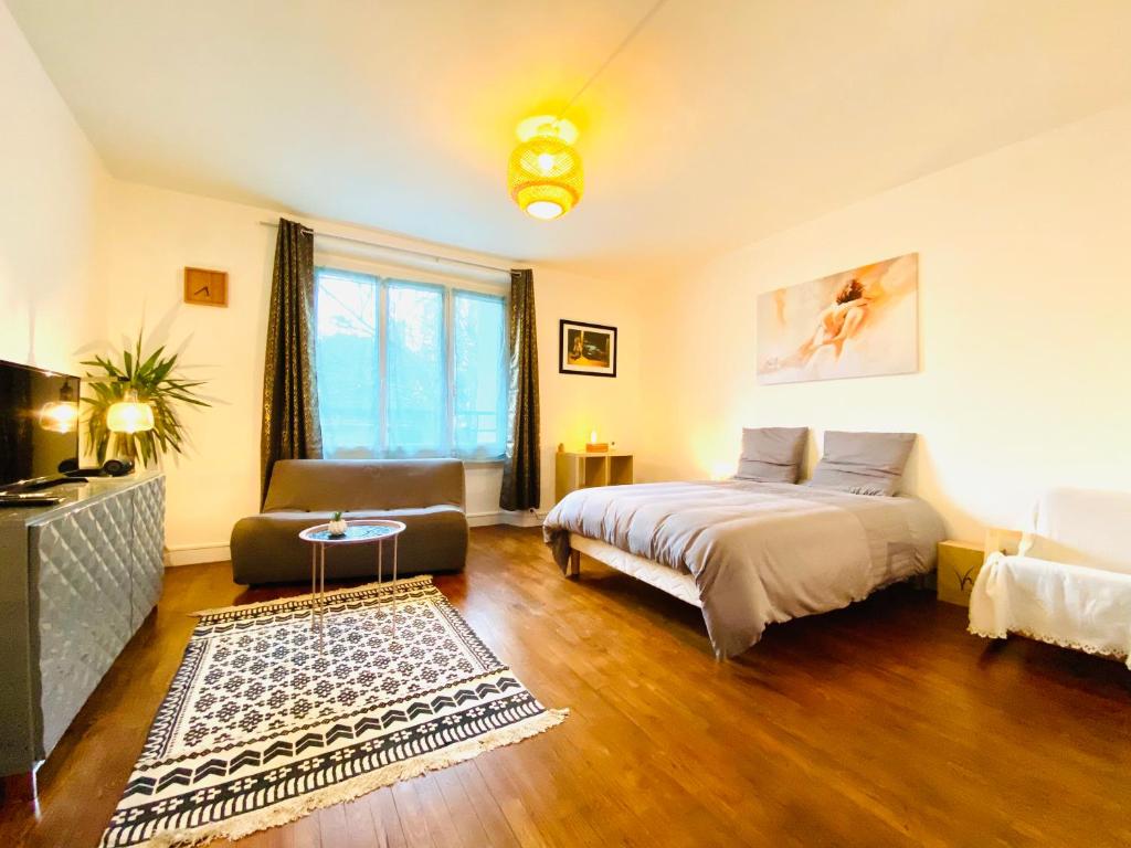圣纳泽尔Le Joly Cocon-Proche mer-wifi-fibre的一间卧室设有一张床和一间客厅。