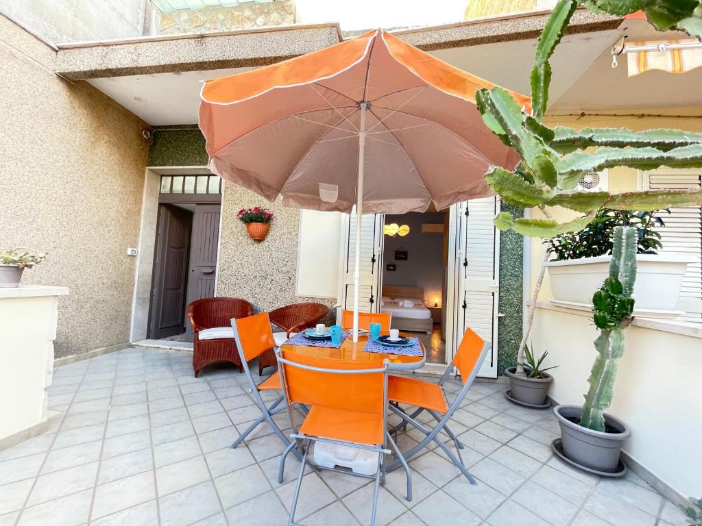 拉古萨码头Casa Palma a 100 passi dal mare的庭院内桌椅和遮阳伞