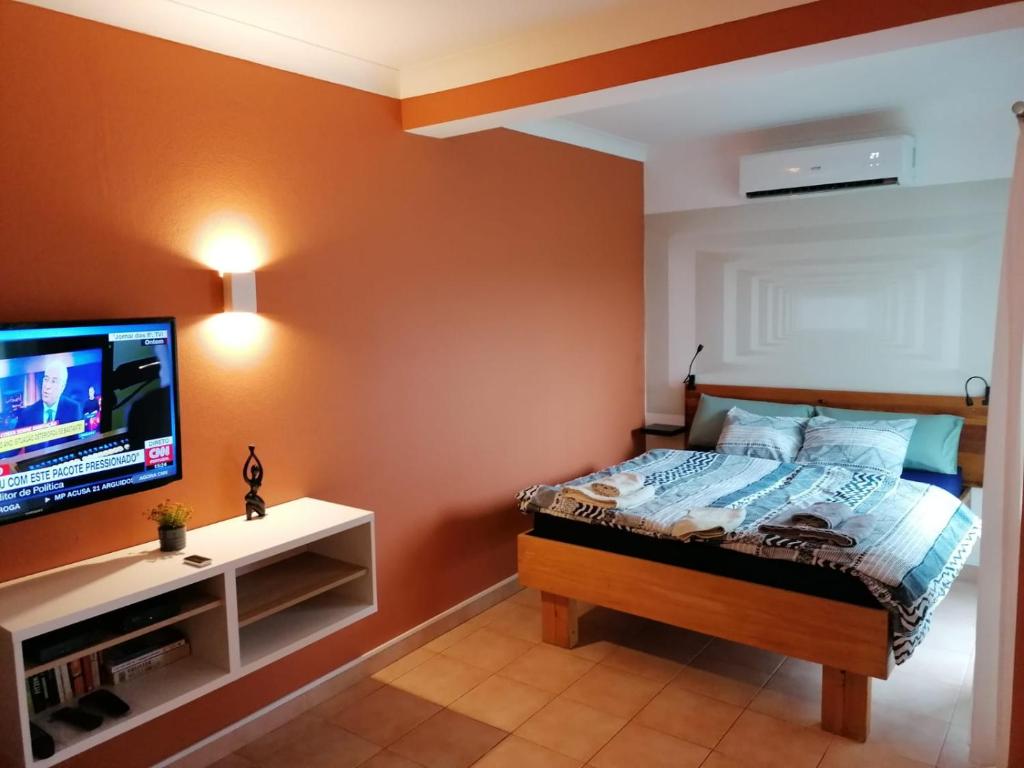 拉戈斯Apartamento Nora的一间卧室配有一张床和一台平面电视