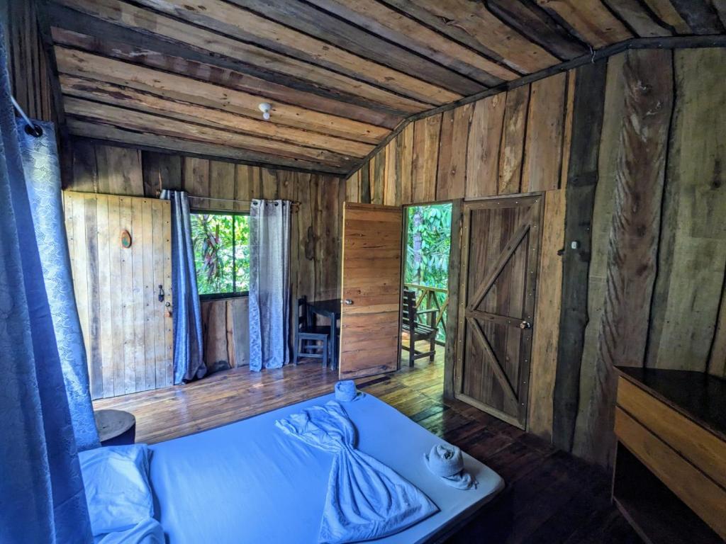 德雷克Citronela Lodge Corcovado的一间卧室设有一张床和木墙